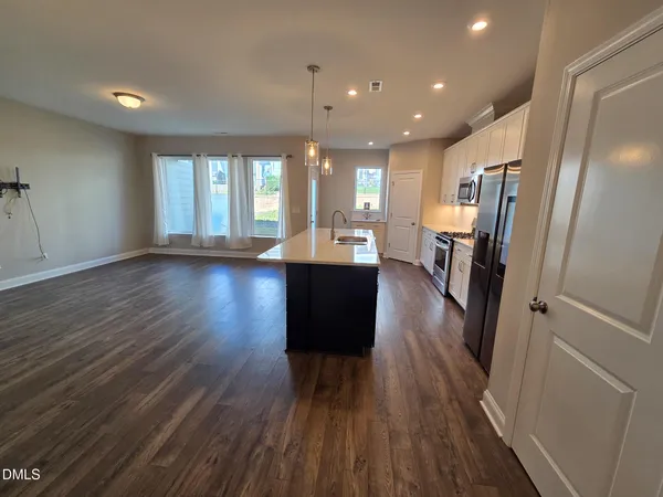a view of a living room with wooden floor and a window