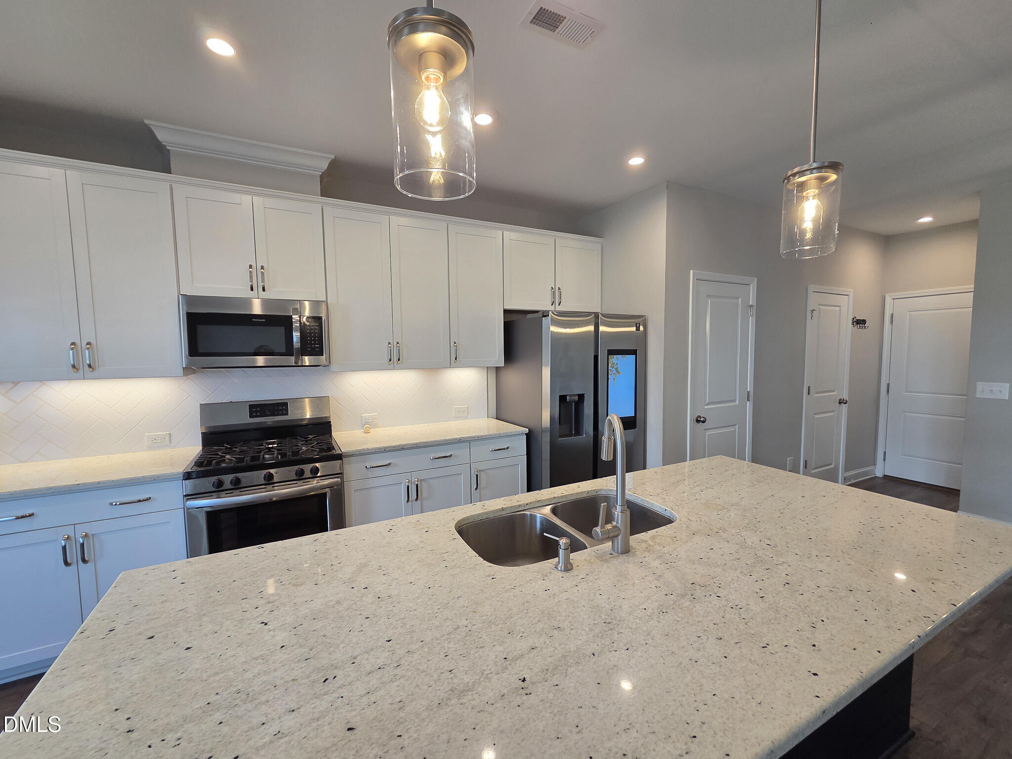 3008 Dunnock Drive Durham, NC 27713 - Photo 10 of 27 a kitchen with refrigerator a stove and a sink with wooden floor