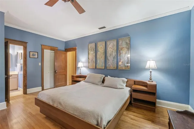 a bedroom with a bed and wooden floor
