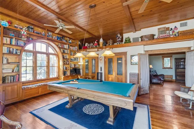 a room with pool table and windows