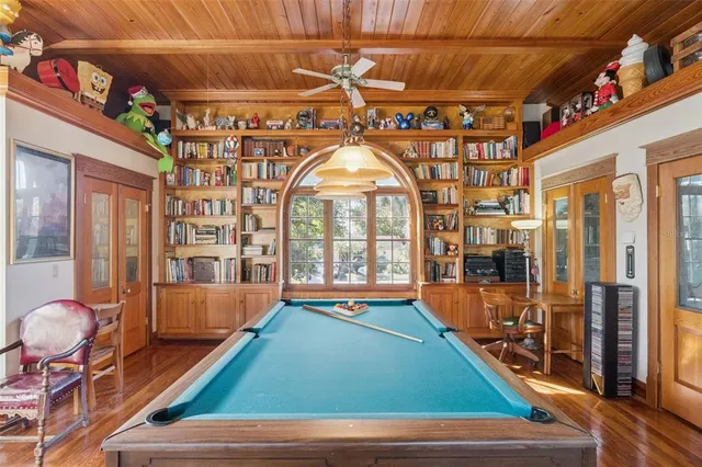 a room with pool table and windows