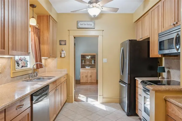 a kitchen with stainless steel appliances granite countertop a sink a stove and a refrigerator