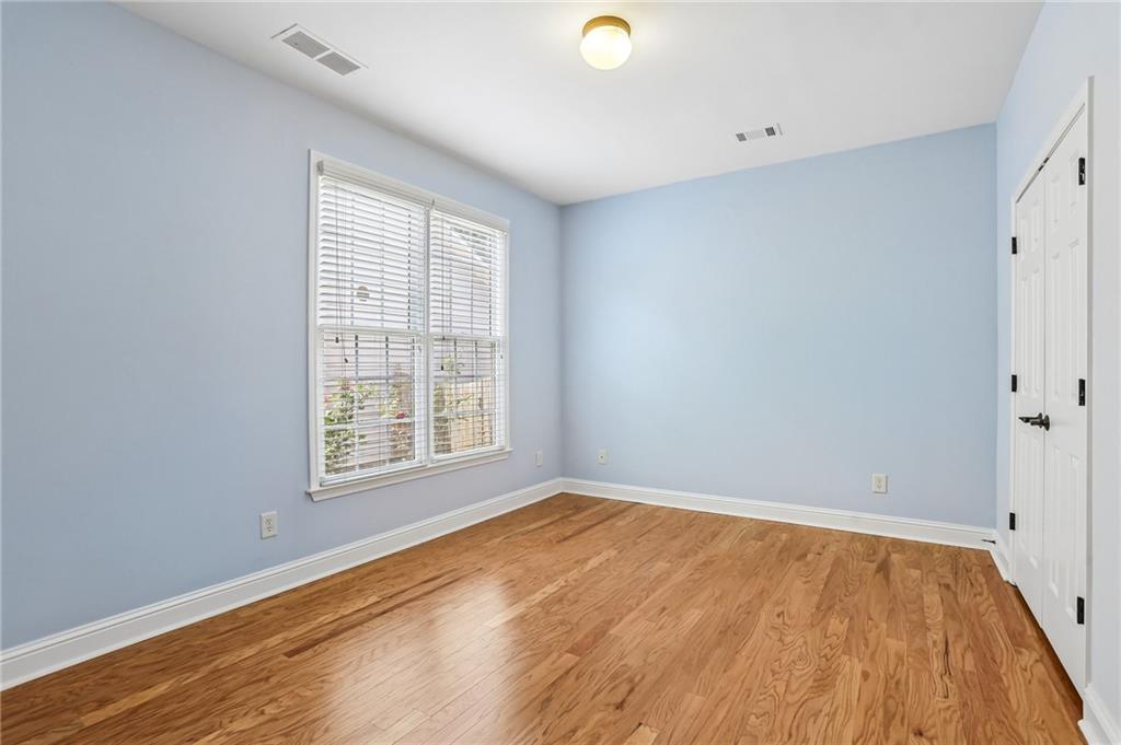 810 Freedom Way Cumming, GA 30040 - Photo 26 of 61 an empty room with wooden floor and windows