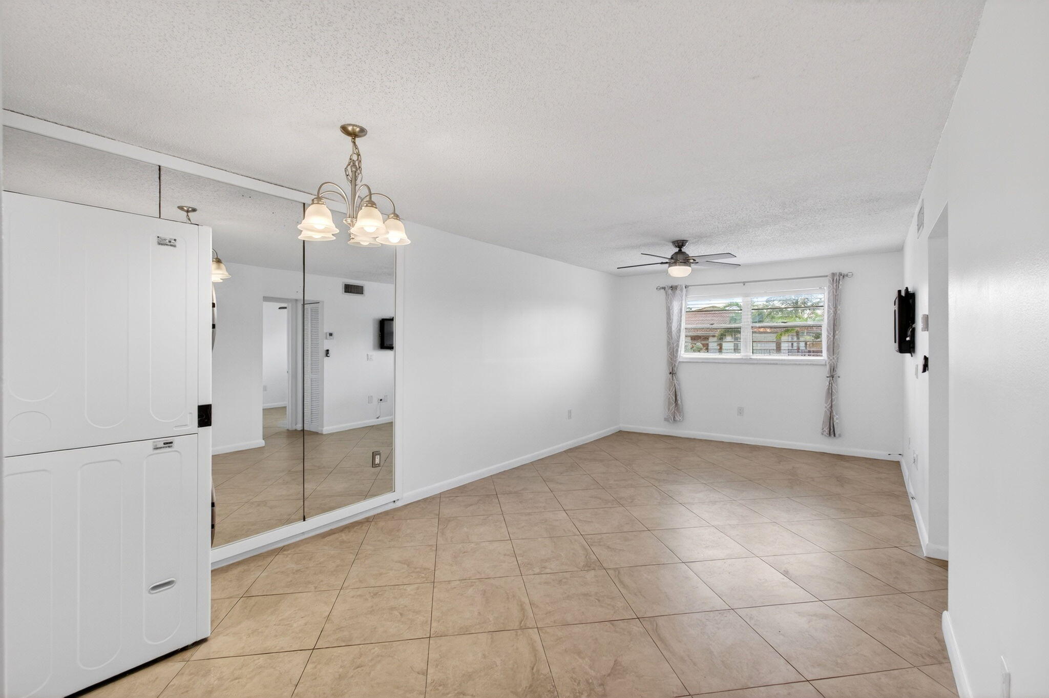 an empty room with kitchen and windows