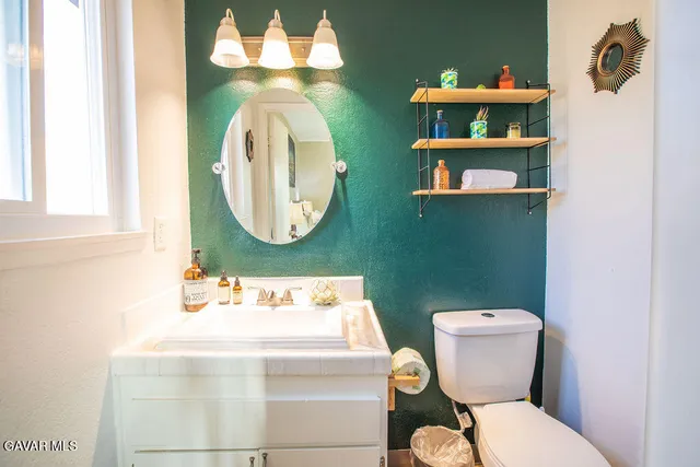 a bathroom with a toilet sink and mirror