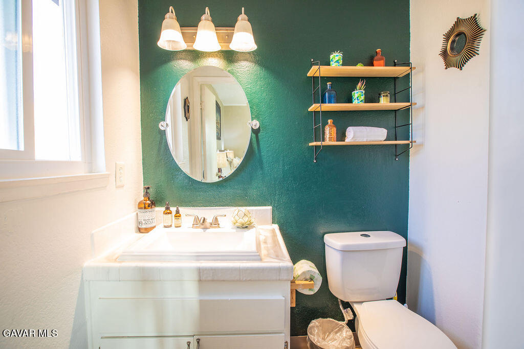 349 South Margalo Street Ridgecrest, CA 93555 - Photo 11 of 14 a bathroom with a toilet sink and mirror