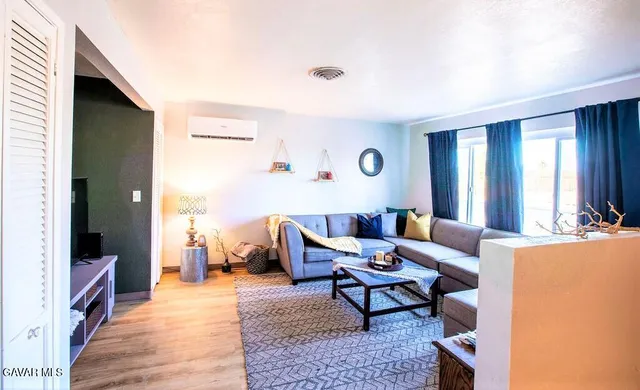 a living room with furniture and a wooden floor