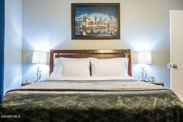 a bedroom with a bed and a painting on the wall