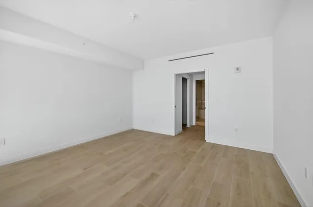 a view of an empty room with wooden floor