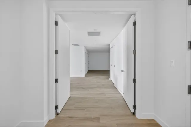 a large kitchen with stainless steel appliances a large counter top and a wooden floor