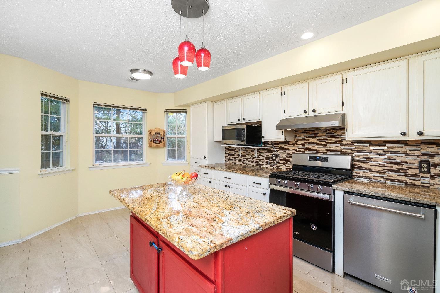 231 Nebula Road Piscataway, NJ 08854 - Photo 12 of 37 a kitchen with kitchen island granite countertop a stove sink and cabinets