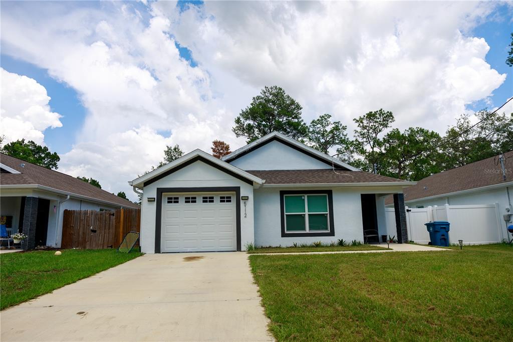 a front view of a house with a garden and yard