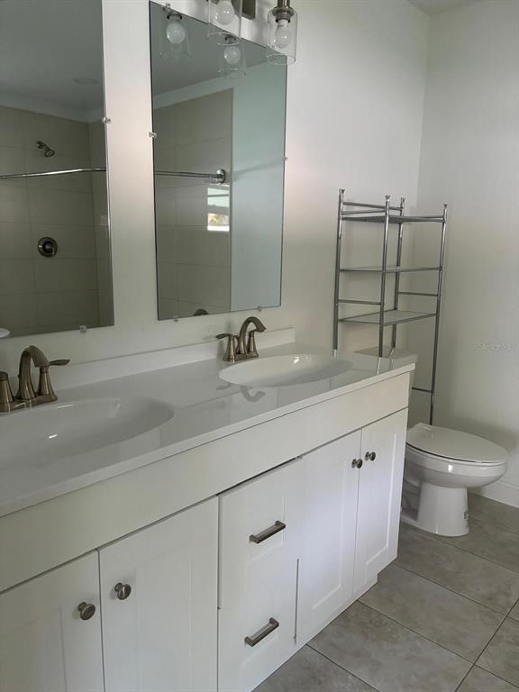 5112 Pacific Spring Hill, FL 34606 - Photo 5 of 13 a bathroom with a double vanity sink toilet and mirror