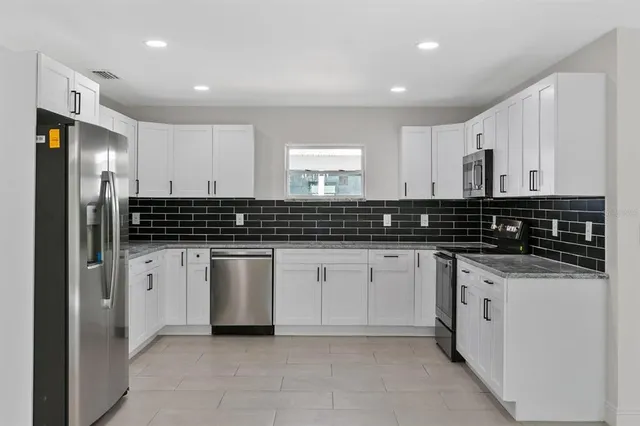 a kitchen with stainless steel appliances a sink stove and refrigerator