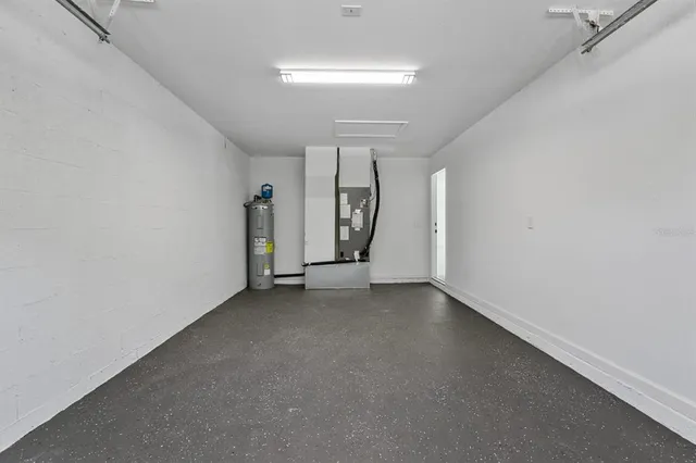 an empty room with chandelier fan and windows