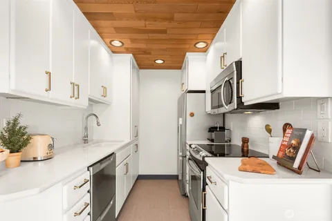 a kitchen with stainless steel appliances granite countertop a sink stove and cabinets