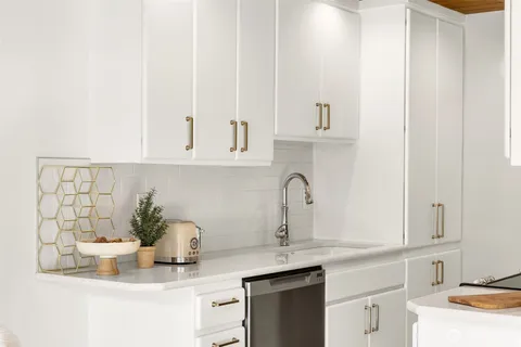 a kitchen with stainless steel appliances granite countertop a sink and a white cabinets