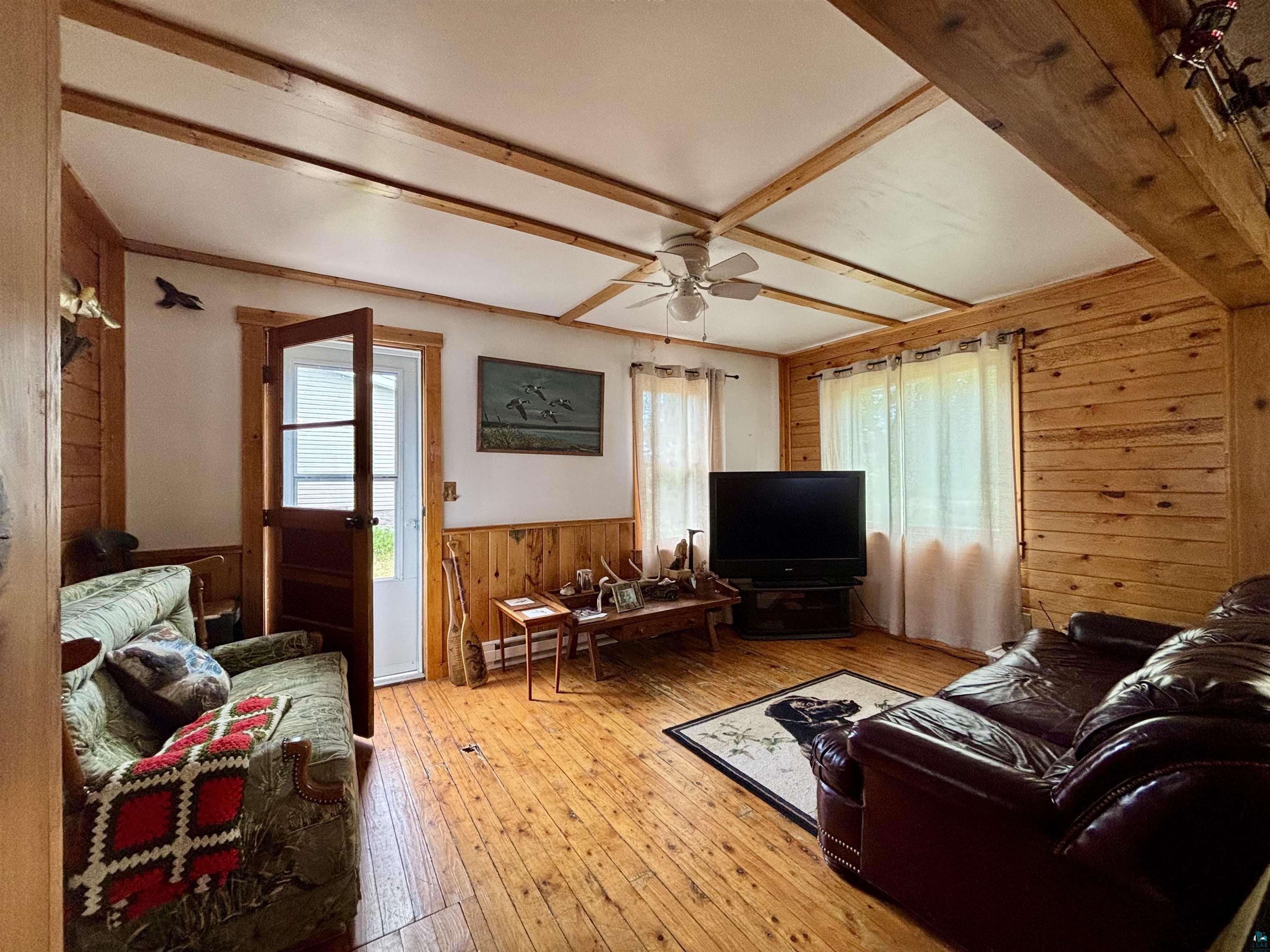 9724 State Highway 1 Isabella, MN 55607 - Photo 7 of 21 Living room with wooden walls, wood-type flooring, a wainscoted wall, and a ceiling fan