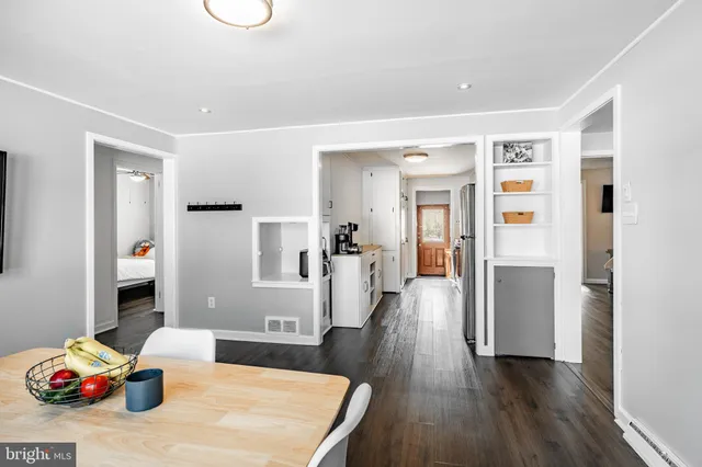 a hallway with a dining table chairs and wooden floor