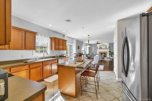 a kitchen with stainless steel appliances a dining table chairs and a refrigerator