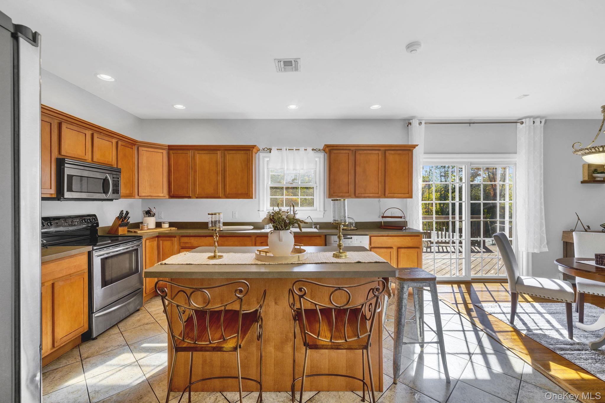 1174 Mountain Road Port Jervis, NY 12771 - Photo 14 of 34 a kitchen with stainless steel appliances granite countertop a stove a sink a microwave a dining table and chairs