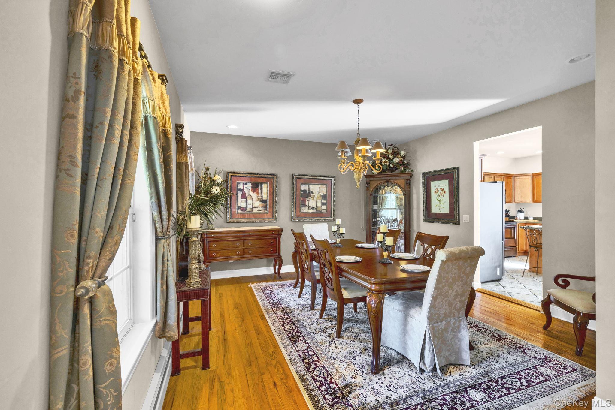 1174 Mountain Road Port Jervis, NY 12771 - Photo 18 of 34 a dining room with wooden floor and a chandelier