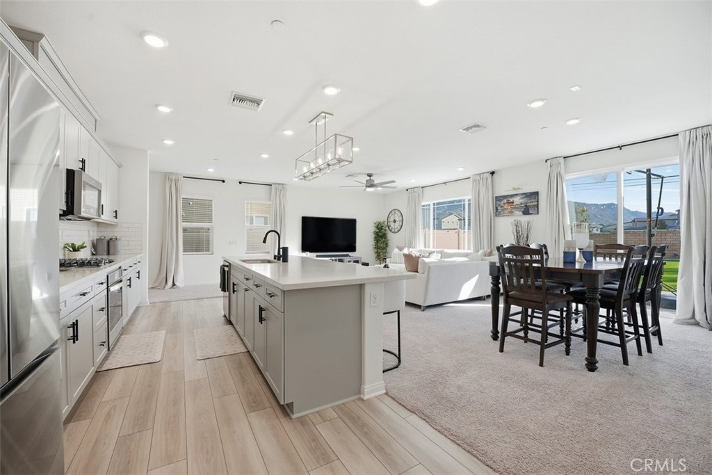7608 Citrusmoon Court Riverside, CA 92507 - Photo 3 of 25 a large white kitchen with lots of counter space and furniture