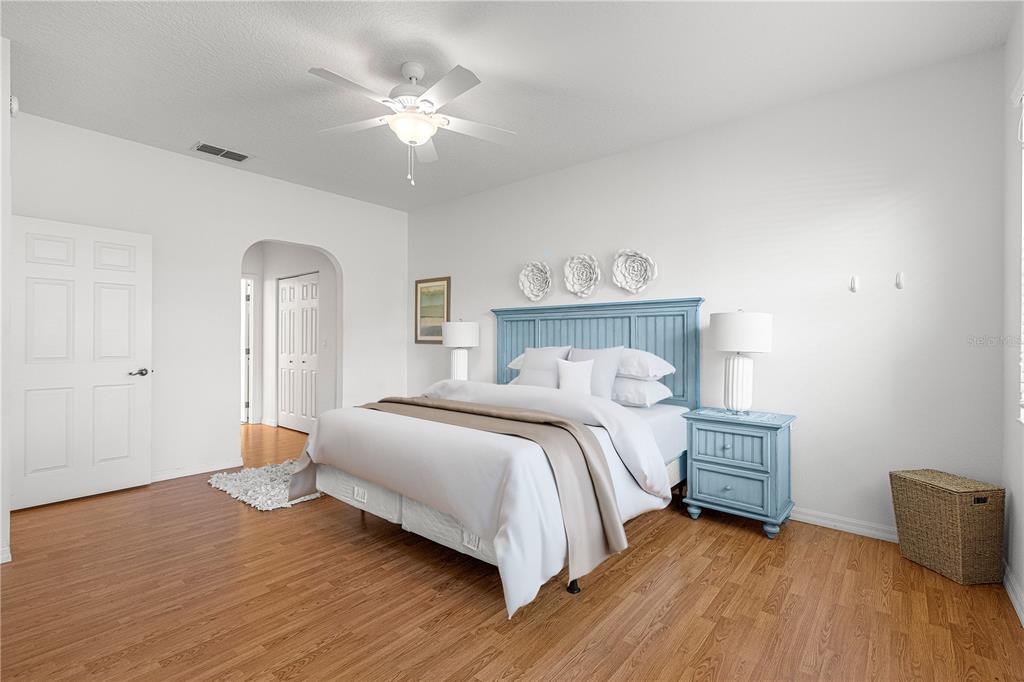 9317 Southwest 94th Loop Ocala, FL 34481 - Photo 18 of 40 a bedroom with a bed and a chandelier