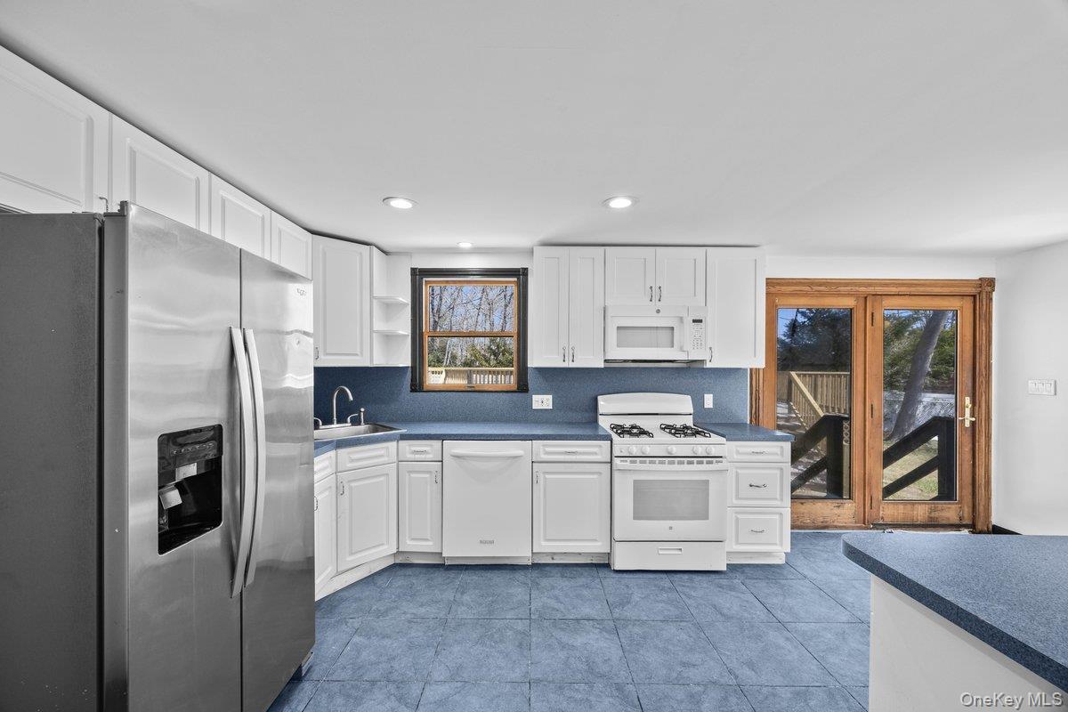 819 Canal Road Mount Sinai, NY 11766 - Photo 19 of 33 The kitchen features white cabinetry, stainless steel appliances, and blue countertops