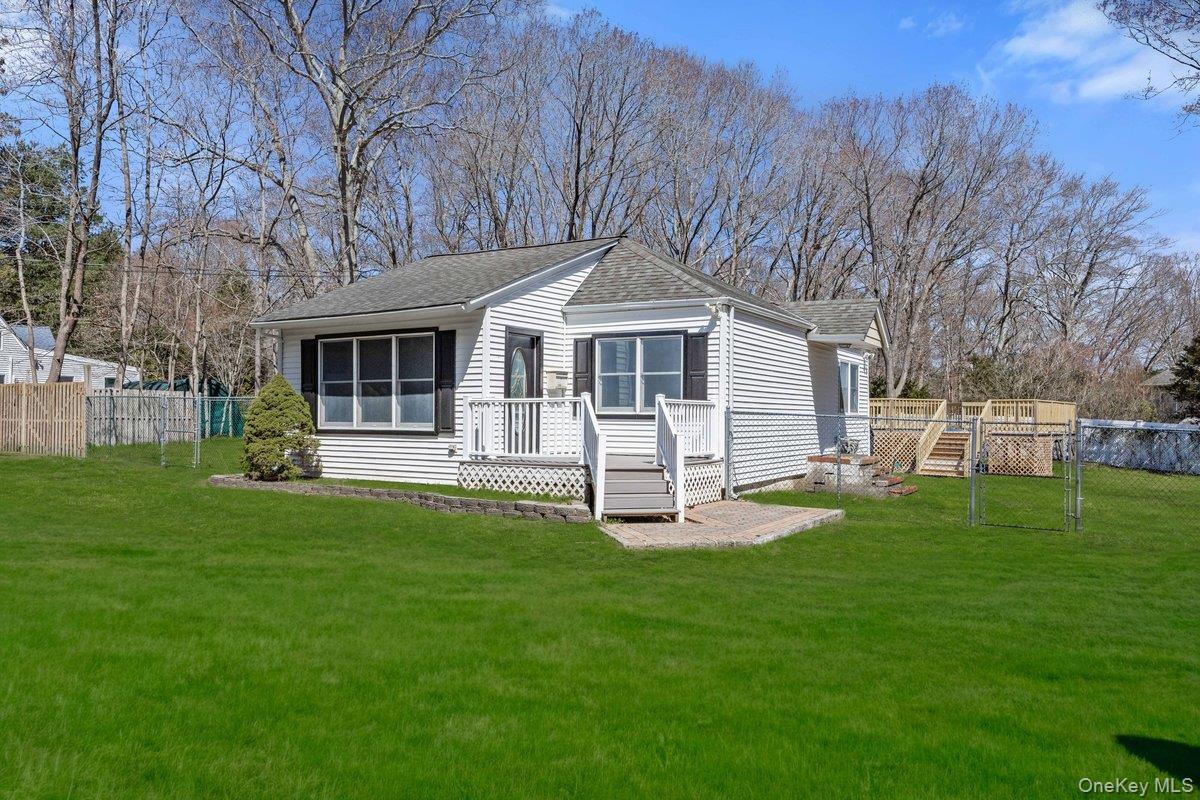 819 Canal Road Mount Sinai, NY 11766 - Photo 3 of 33 The property features a well-maintained lawn and a front porch with white railings and steps