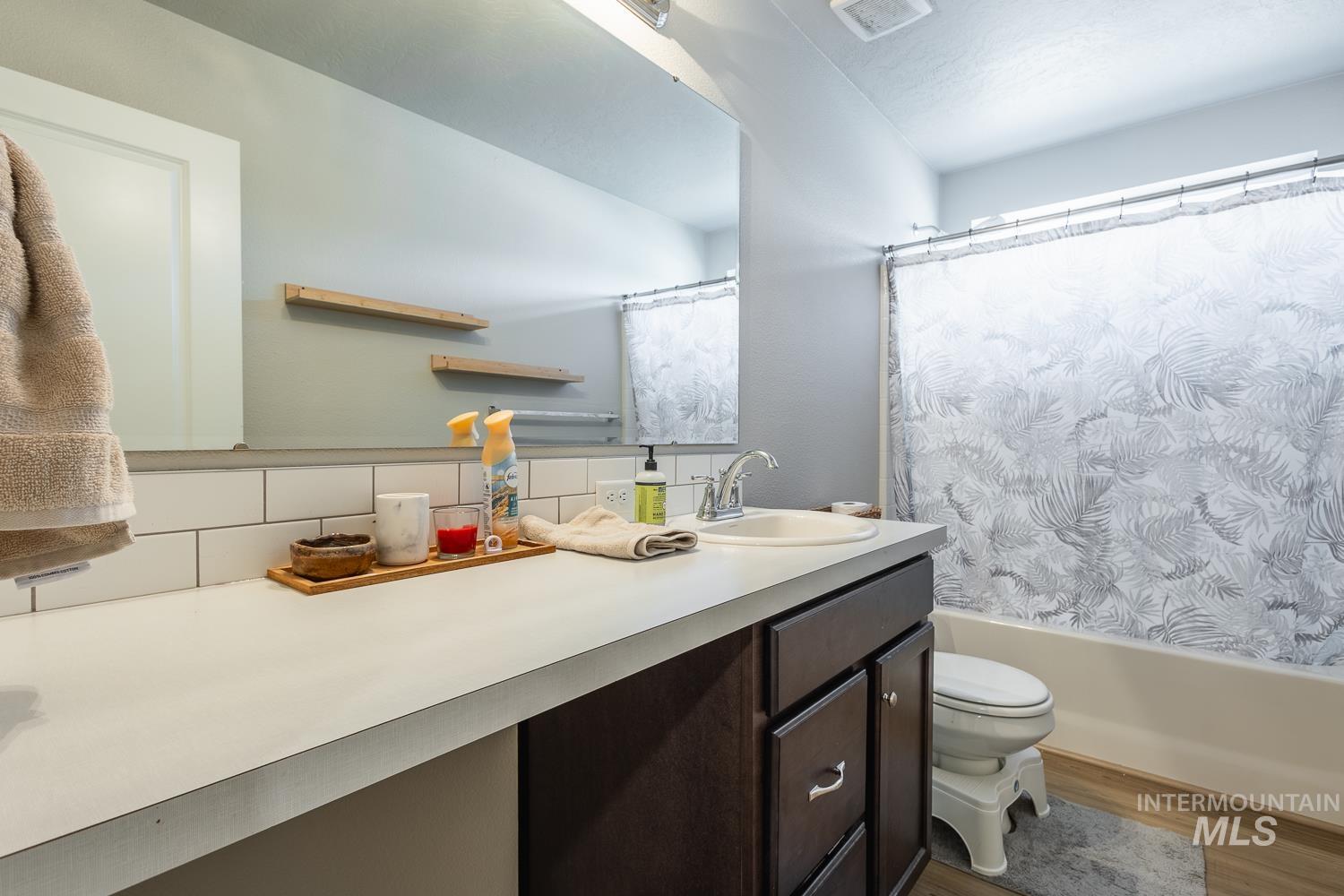 12623 Shadow Peak Street Caldwell, ID 83607 - Photo 37 of 50 Bathroom featuring a single vanity with dark wood-finish cabinetry, a drop-in sink, and a large wall-mounted mirror