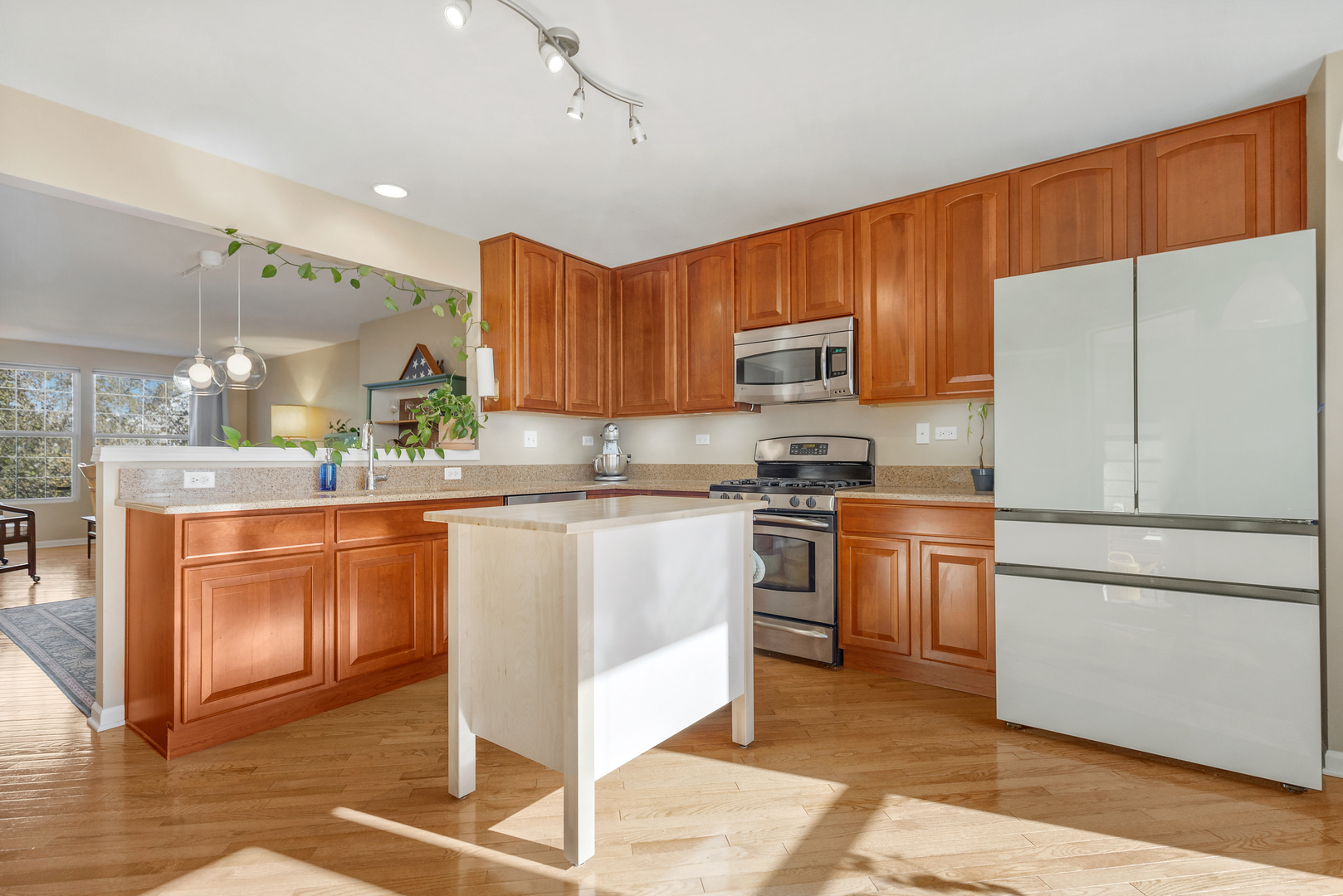 2451 Anna Way Elgin, IL 60124 - Photo 10 of 26 a kitchen with stainless steel appliances granite countertop a refrigerator a sink dishwasher a stove top oven a kitchen island and chairs with wooden floor