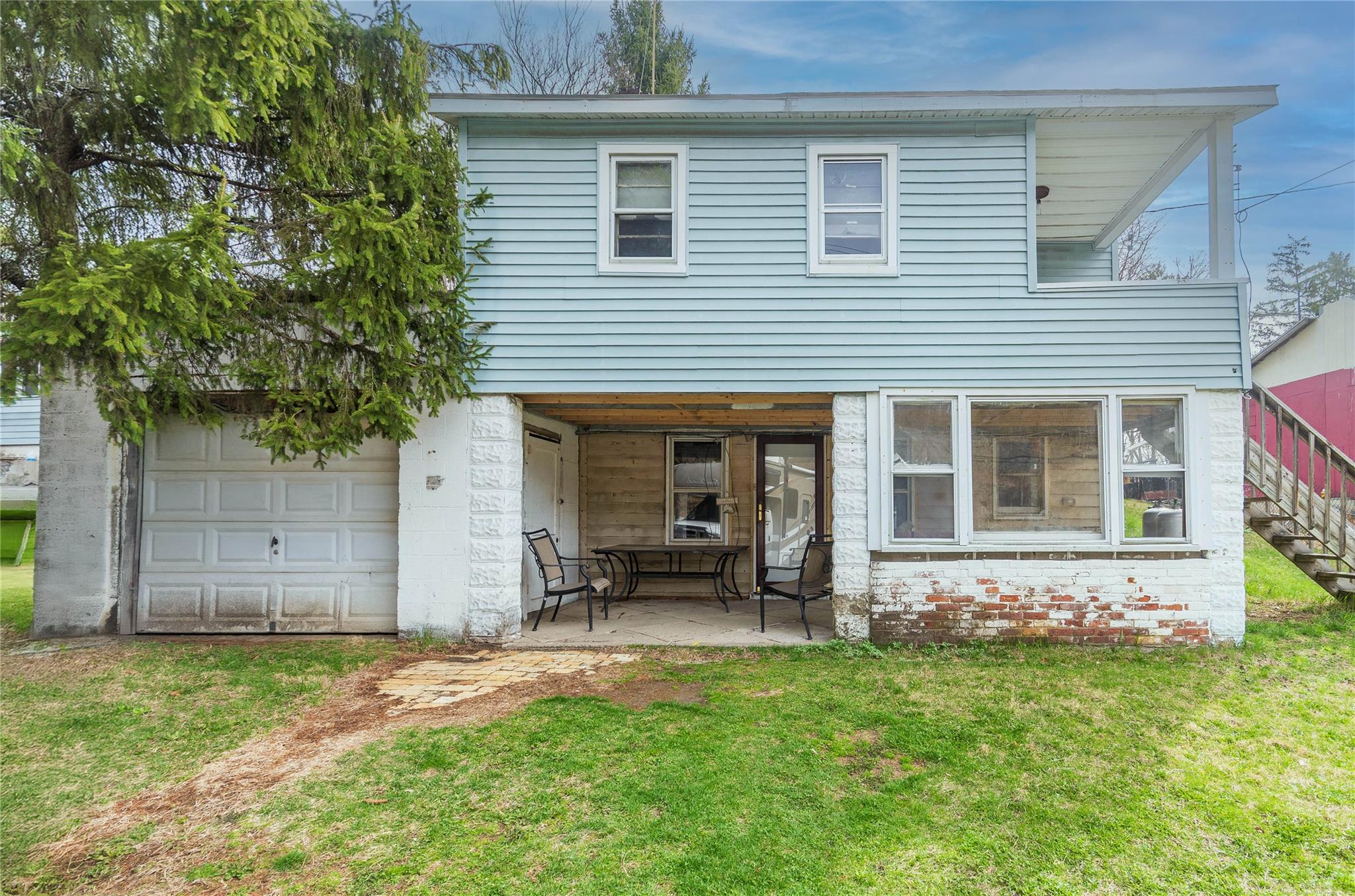 20 Lattintown Road Newburgh, NY 12550 - Photo 1 of 1 Traditional-style house with a front lawn, a patio area, and a garage