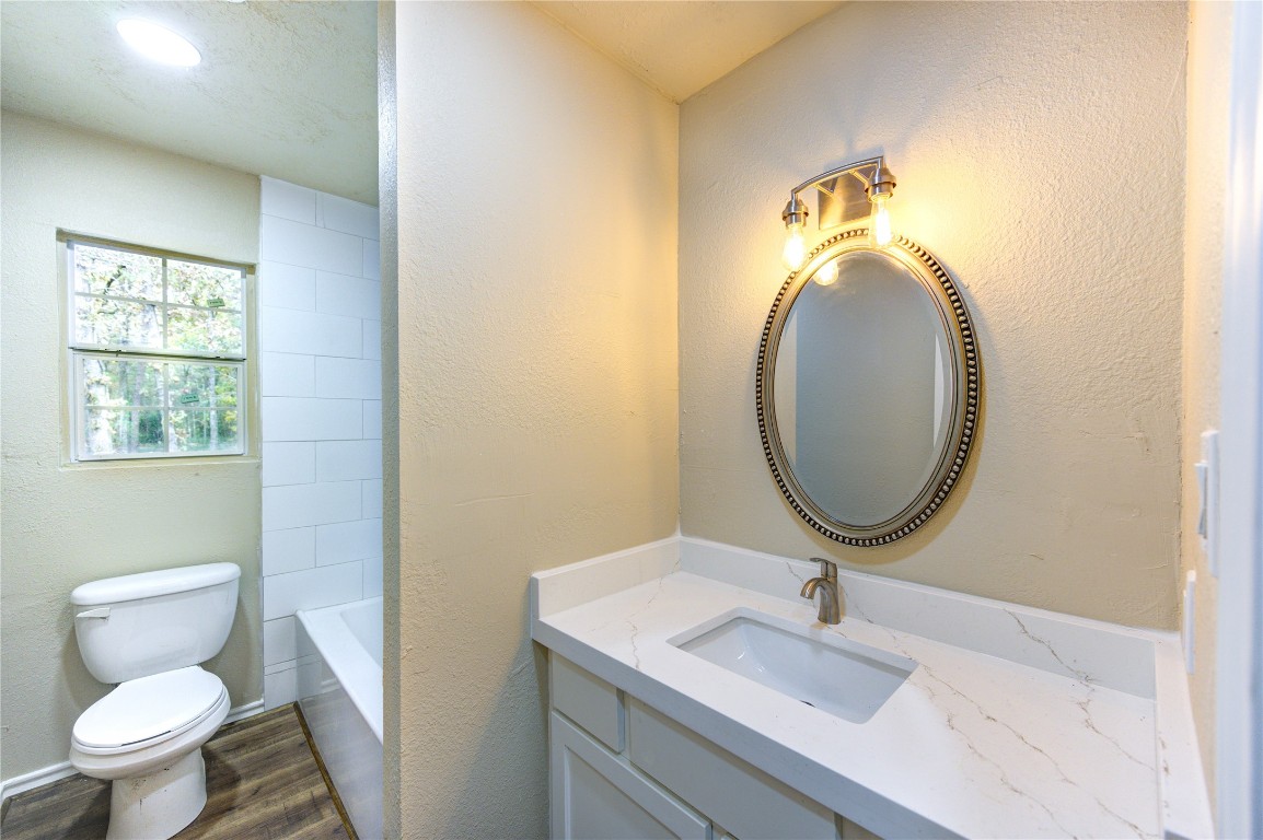 235 6th Street Trinity, TX 75862 - Photo 13 of 29 a bathroom with a toilet a sink and a mirror