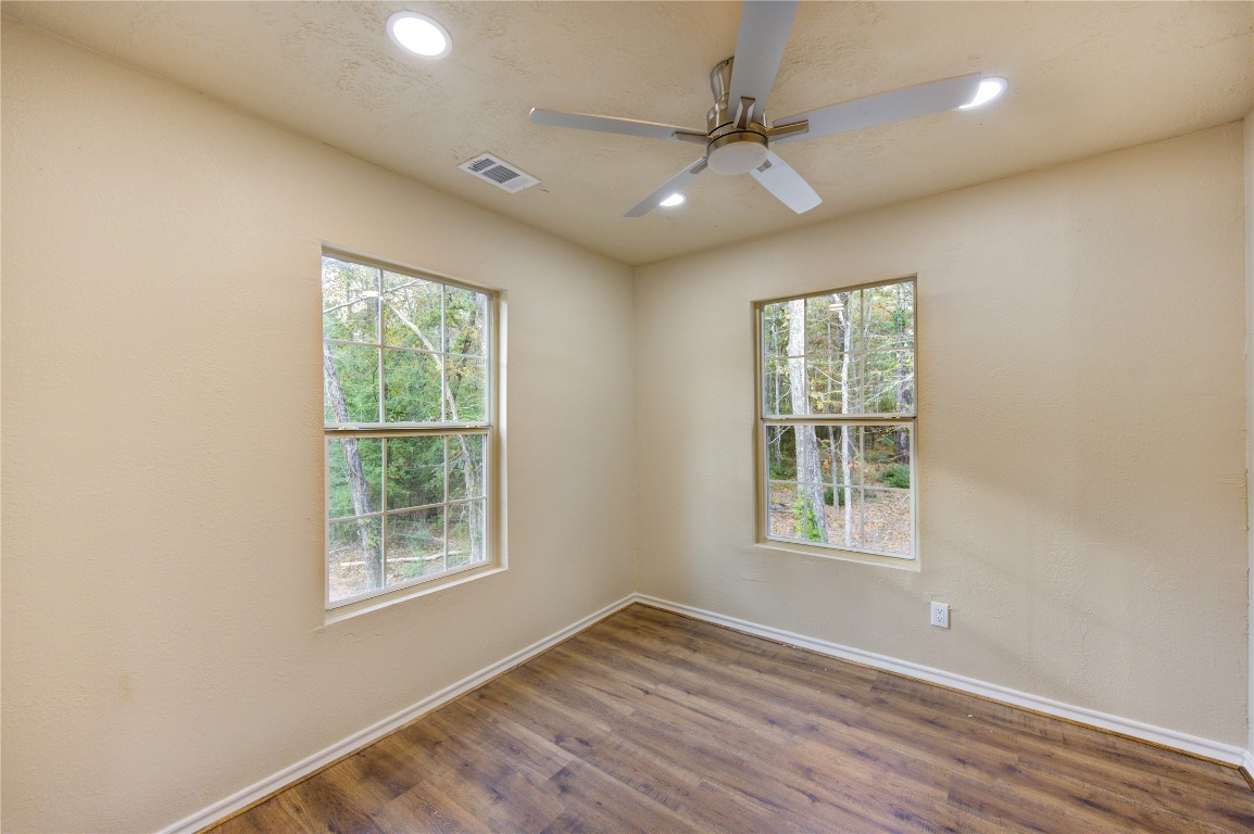 235 6th Street Trinity, TX 75862 - Photo 18 of 29 an empty room with wooden floor fan and windows