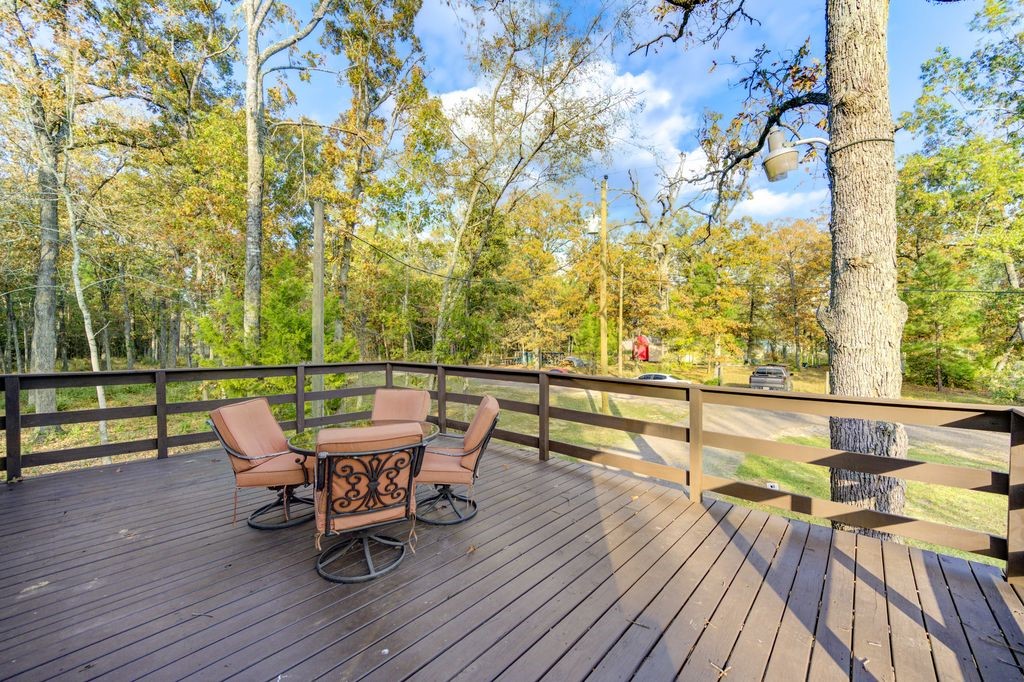 235 6th Street Trinity, TX 75862 - Photo 28 of 29 a roof deck with table and chairs and wooden floor