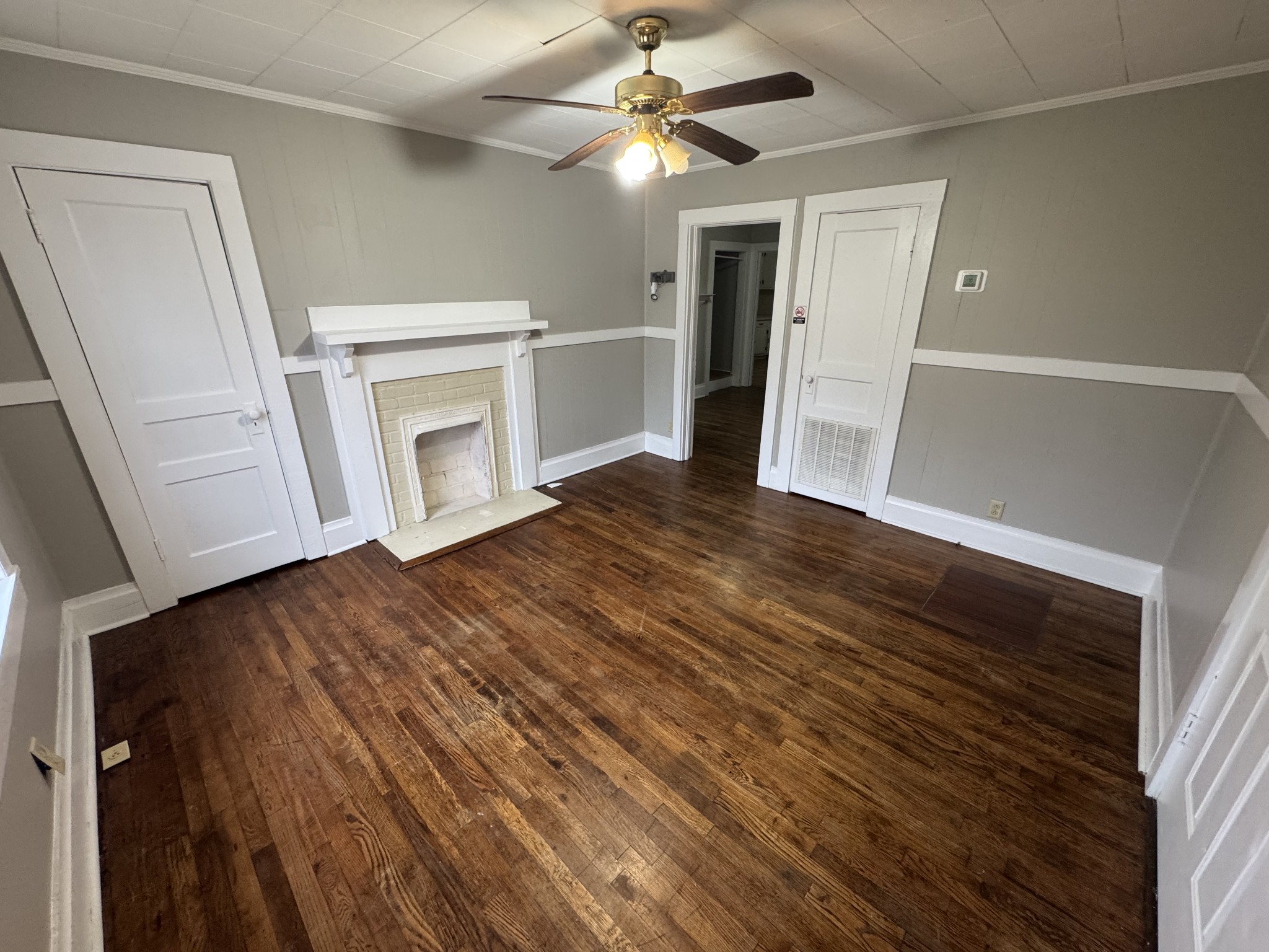 a view of a livingroom with wooden floor and a ceiling fan