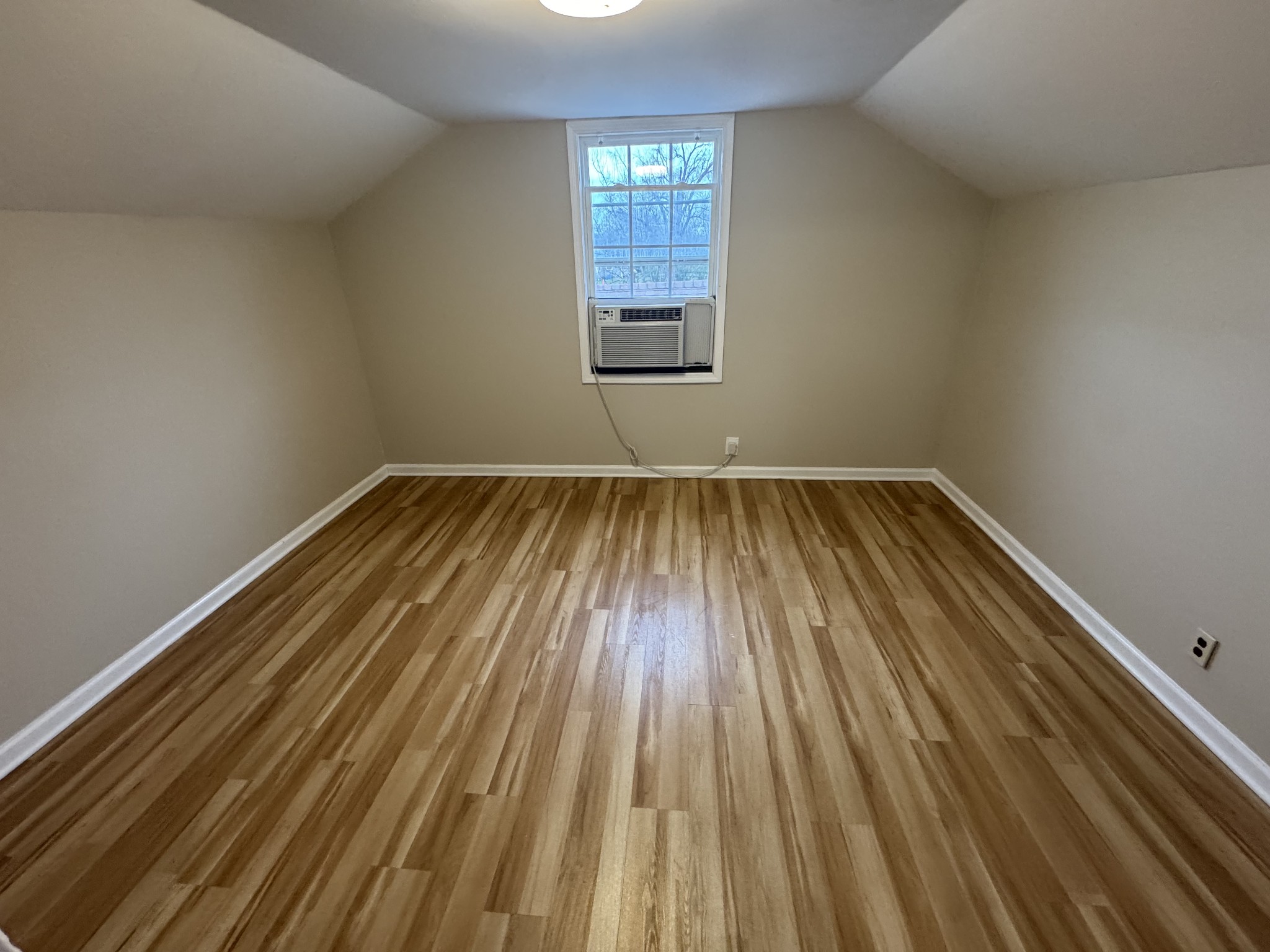 835 Bridge Avenue, Unit B Murfreesboro, TN 37129 - Photo 8 of 10 a view of an empty room with wooden floor and a window