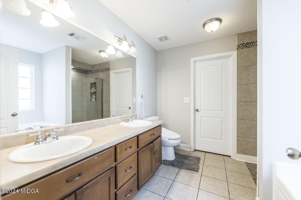 104 Weatherwood Road Kathleen, GA 31047 - Photo 19 of 35 a spacious bathroom with a double vanity sink mirror and toilet