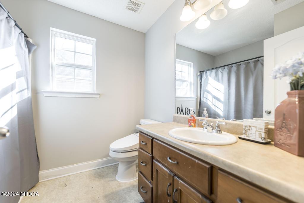 104 Weatherwood Road Kathleen, GA 31047 - Photo 26 of 35 a bathroom with a double vanity sink toilet and a mirror