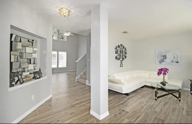 a living room with furniture and wooden floor