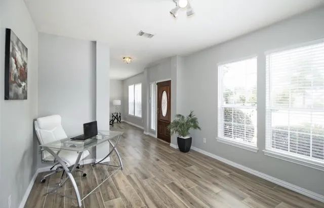 a living room with furniture and wooden floor
