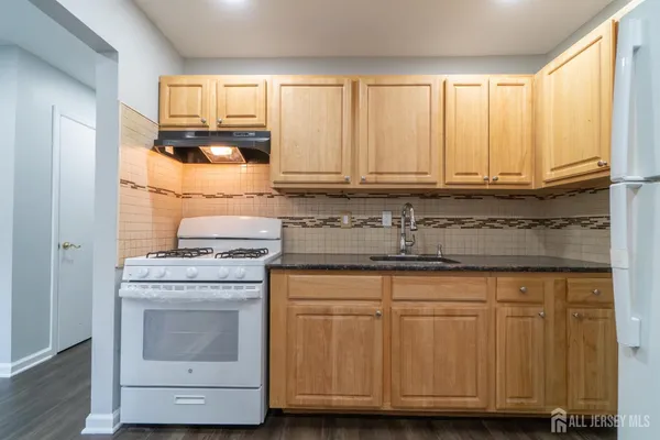 a kitchen with granite countertop cabinets and white appliances