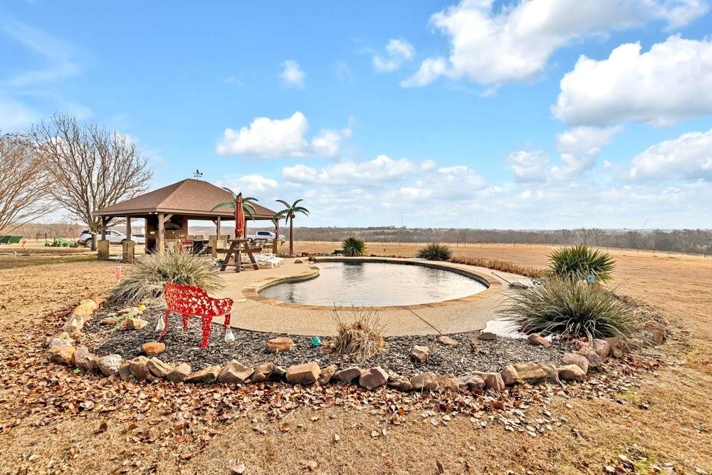 7709 Fm 902 Sherman, TX 75092 - Photo 29 of 39 a view of swimming pool with lawn chairs under an umbrella