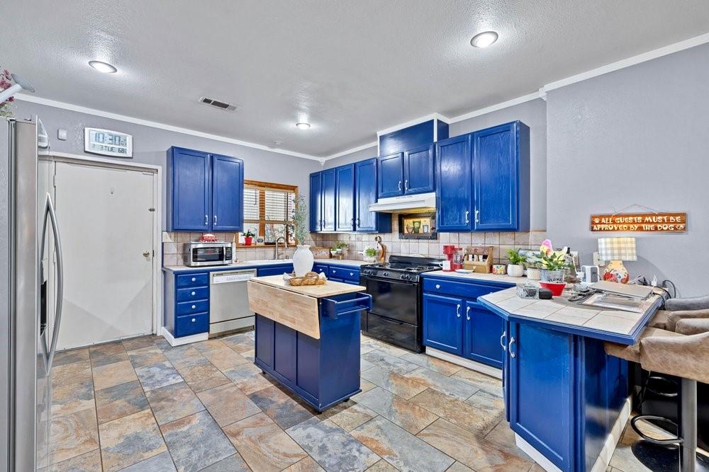 7709 Fm 902 Sherman, TX 75092 - Photo 9 of 39 a kitchen with a refrigerator sink and wooden cabinets