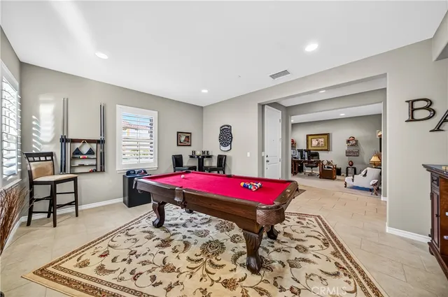 a living room with furniture pool table and a large window