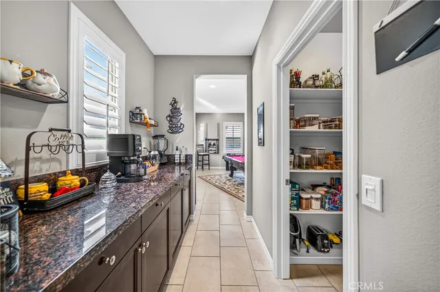 a kitchen with granite countertop lots of clutter and stainless steel appliances
