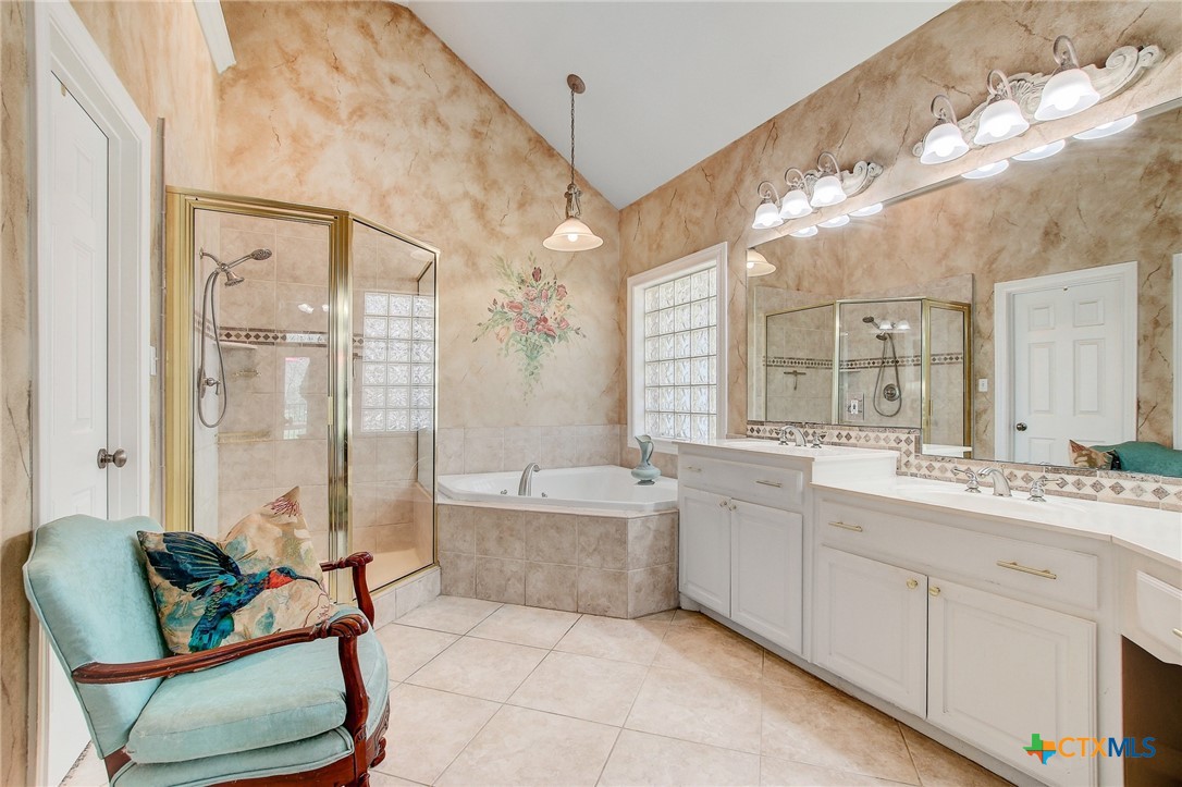 200 Carriage House Road Salado, TX 76571 - Photo 22 of 43 a spacious bathroom with a double vanity sink a large mirror a bathtub and next to a window