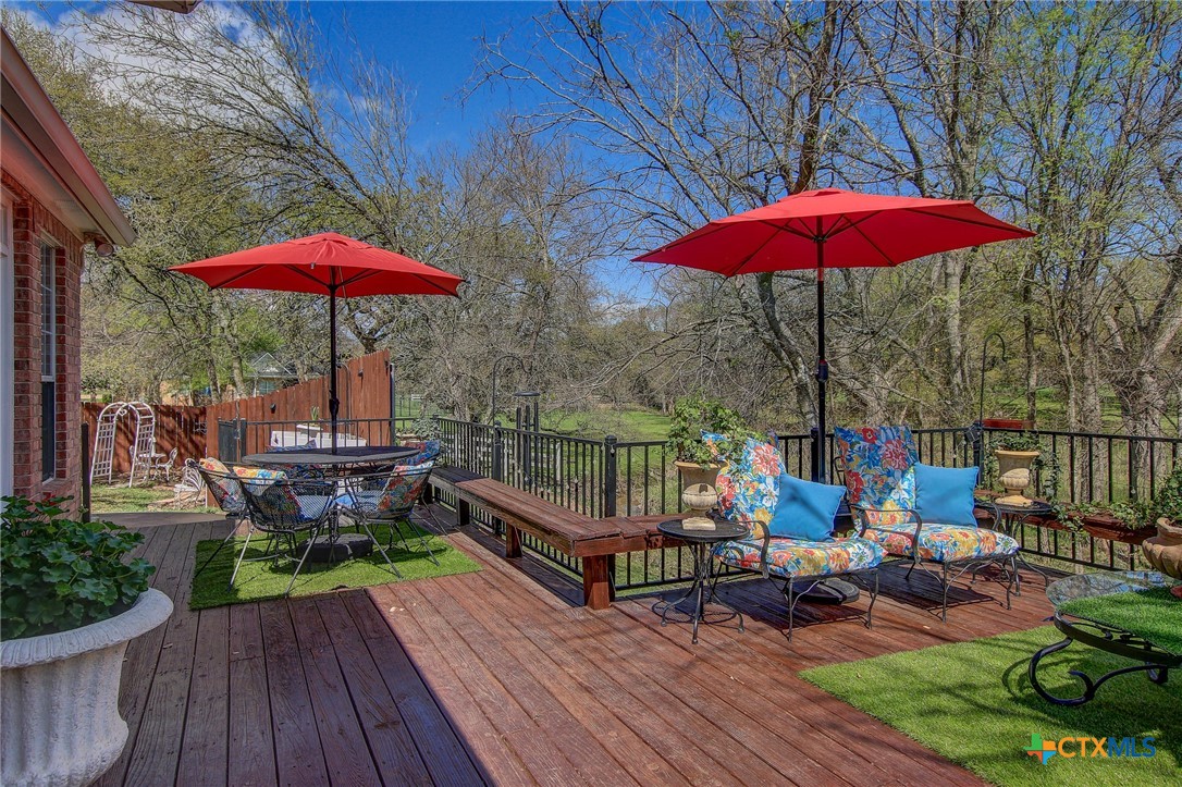 200 Carriage House Road Salado, TX 76571 - Photo 30 of 43 an outdoor sitting area with umbrella and wooden floor
