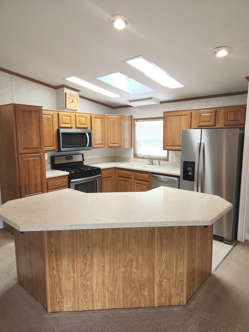 1027 Cherry Street Manteno, IL 60950 - Photo 7 of 20 a kitchen with kitchen island a stove a refrigerator and a refrigerator
